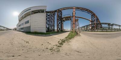 spherical 360 hdri panorama near industrial architecture and communications, pipes and metal structures in equirectangular seamless projection photo