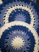 Blue, white round crochet elements and balls of yarn. Crochet texture, place for an inscription, adapted for mobile phone photo