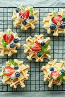 Freshly baked waffles with strawberries and blueberries photo