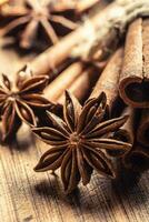 Detail of star anize and cinnamon sticks on a vintage wooden surface photo