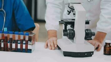 médical ou scientifique chercheur ou homme médecin à la recherche à une tester tube de clair Solution dans une laboratoire video