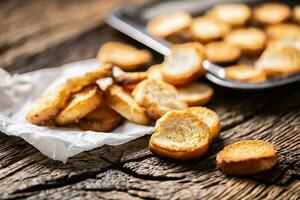 Freshly baked crispy bake rolls with goldish colour served in the paper on a rustic wooden desk photo