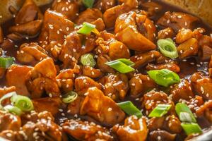 Detail of Asian style cooked chicken with spring onions and seesame seeds photo