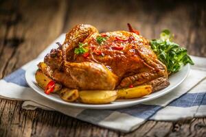 Roasted chicken and american potatoes with chili peppers and herbs photo