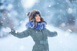 Beautiful smiling young woman in warm clothing. The concept of portrait in winter snowy weather photo