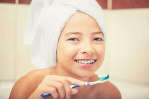 Adolescente niña en el baño con cepillo de dientes. dental higiene foto