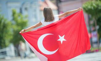 contento niña turista caminando en el calle con Turquía bandera foto