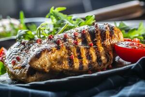 Chicken breast grilled with spices peper salt tomatoes and arugula photo