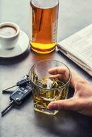 Glass of alcohol hand man the keys to the car and irresponsible driver photo