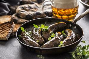 Roasted sausages in pan with bread herbs and draft beer. photo