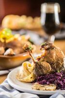 Roasted christmas duck leg red cabbage dumplings liver draft beer and baked buns photo