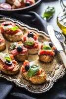 Bruschetta toast with mozzarella tomatoes olives and basil. photo