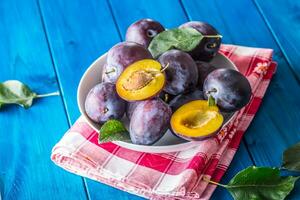 Plums. Fresh juicy plums in a bowl on a wooden or concrete board photo