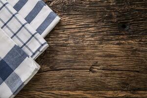 Top view of checkered tablecloth or napkin on empty wooden table photo