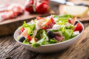 Salad. Fresh summer lettuce salad.Healthy mediterranean salad olives tomatoes parmesan cheese and prosciutto. photo