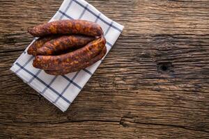 Sausages. Smoked Sausages. Chorizo sausages with vegetable rosemary spices and kitchen utensil. photo