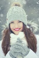 Beautiful smiling young woman in warm clothing. The concept of portrait in winter snowy weather photo