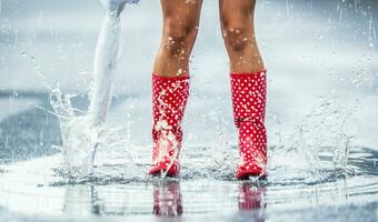 mujer piernas en punteado rojo caucho botas con paraguas saltando en el verano primavera o otoño charcos foto