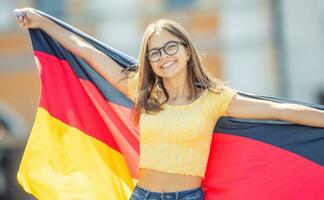 atractivo contento joven niña con el Alemania bandera foto