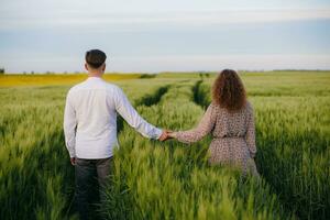 Couple in love on green field of wheat photo