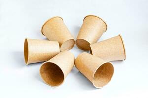 Stack of paper mugs. Six disposable paper cups made of cardboard kraft paper. photo