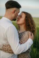 Couple in love on green field of wheat photo