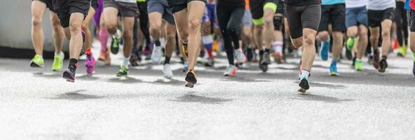 Runners in shorts and trainers start running a competition, with only their legs visible. photo