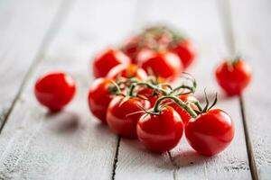 Freshly grown tomartoes in the garden with lovely red colour full of summer sun rays photo