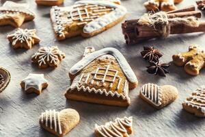 House with gingerbread and other Christmas cookies along with cinnamon and pine cones photo