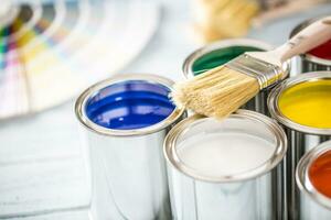 Paint cans brushes and color palette on table photo