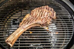 Beef tomahawk steak grilled on a grill - close-up photo