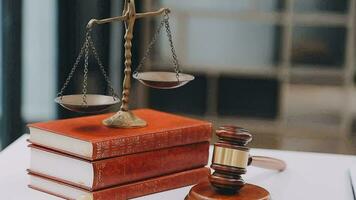 Business and lawyers discussing contract papers with brass scale on desk in office. Law, legal services, advice, justice and law concept picture with film grain effect video