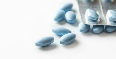 Blue pills loose lying on a white isolated background photo