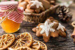 Gingerbread christmas cookies with jar of honey on kitchen table - Close-up photo