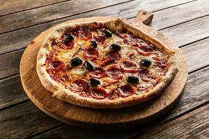 Pizza diavola traditional italian meal with spicy salami peperoni chili and olives photo