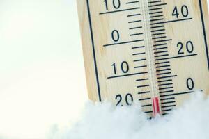 termómetro en nieve muestra bajo temperaturas debajo cero. bajo temperaturas en grados Celsius y Fahrenheit. frío invierno clima veinte debajo cero foto