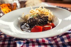 Confit beef steak with sauce fried onion bread draft beer and decoration in pub or restaurant photo