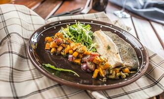 Roasted fish fillet with pumpkim pieces and herb decoration in pub or restaurant photo