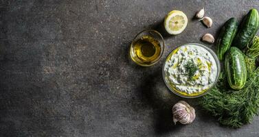 Tzatziki sause in a glass bowl dill cucumber olive oil lemon and garlic photo