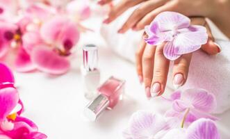 Beautiful nail manicure with decoration from pink orchid photo