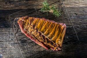 Smoked raw pork ribs and rosemary herbs on wooden board photo