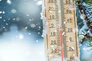 termómetro en nieve muestra bajo temperaturas en Celsius o farenheit foto