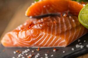 Raw Salmon fillets on slate and wooden board photo