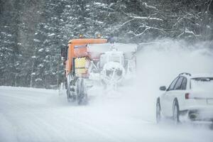 pobre la carretera visibilidad de un coche conducción Derecha detrás un nieve arado durante invierno la carretera mantenimiento foto