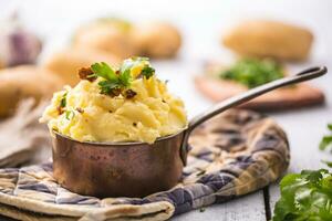 Mashed potatoes in pan decorated with parsley herbs. photo