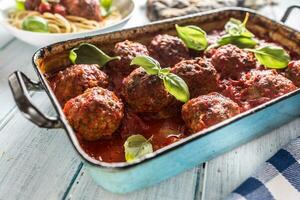 Delisious italian meal meat beef balls with pasta spaghetti and basil in vintage roaster pan photo