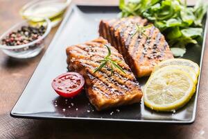 Grilled  salmon fillet with salad tomatoes and sesame photo