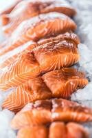 Salmon fillets portioned on ice and empty kitchen board photo