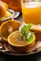 Fresh oranges juicer juice tropical fruits and herbs on concrete board photo