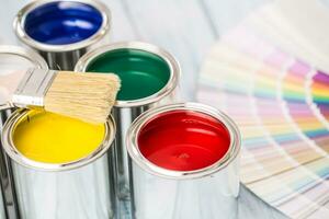 Paint cans brushes and color palette on table photo